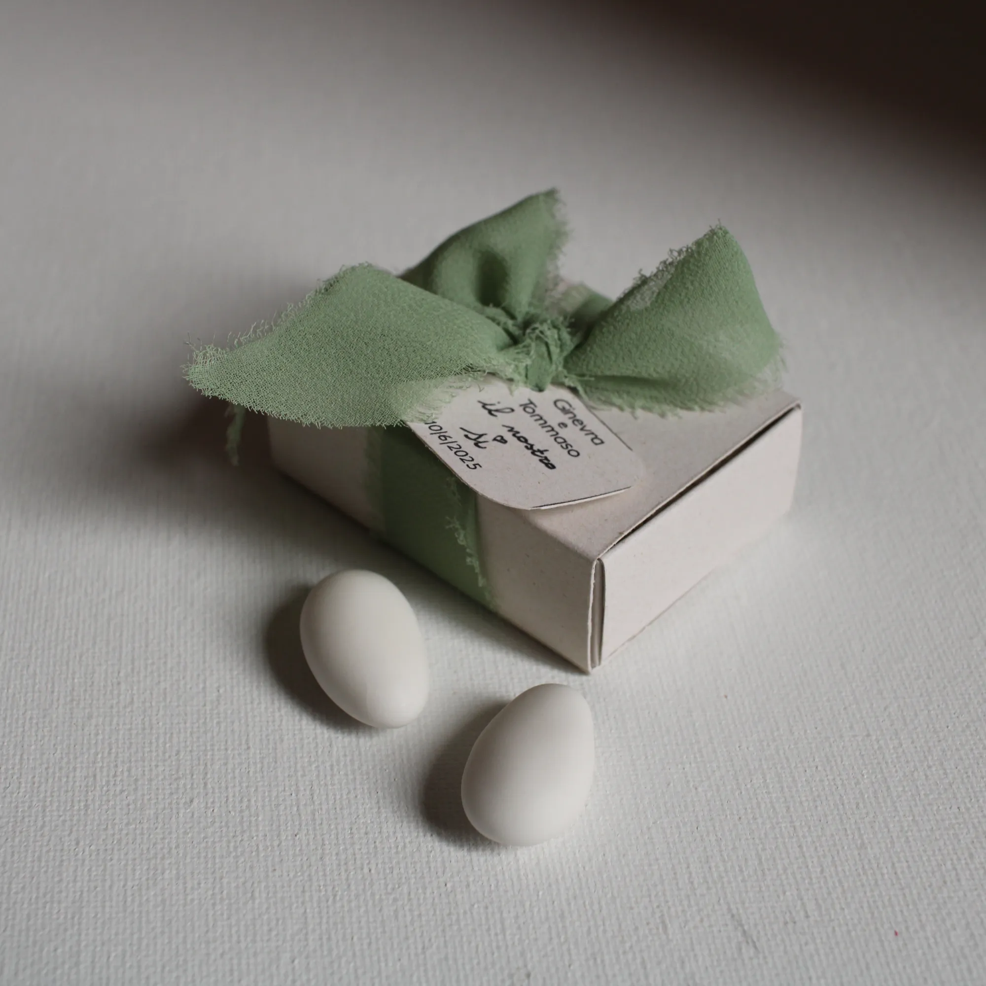 Dettaglio del tag personalizzato e del nastro in chiffon verde salvia